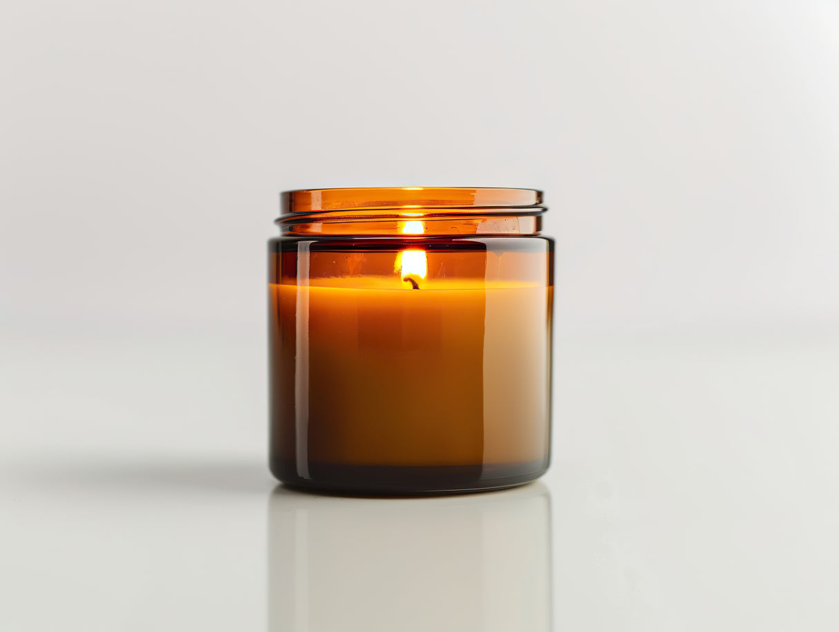 A lit brown glass container candle