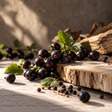 Black currants on an oak board with black pepper berries 