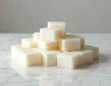 Stack of white wax melt cubes on a marble surface